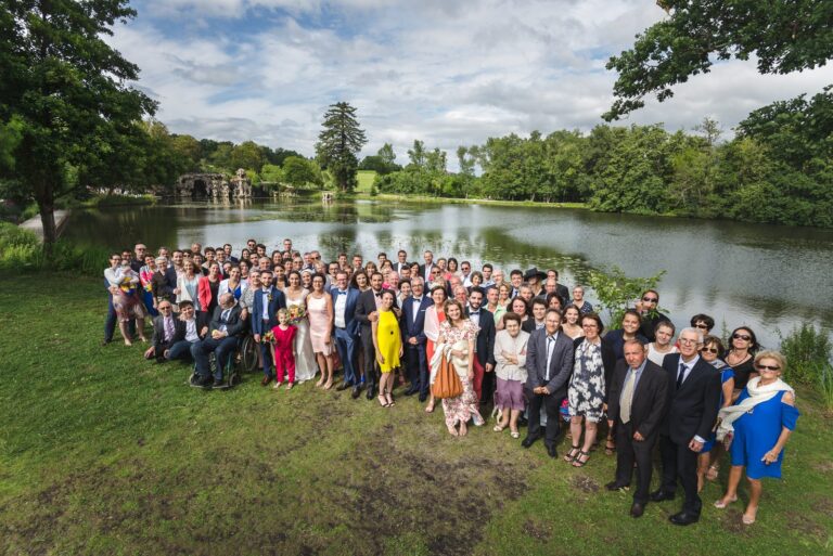 Grand étang du parc du Château de Cujac, à Saint-Aubin-de-Médoc, avec les invités rassemblés sur la pelouse devant un pont de pierre