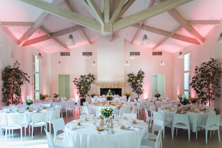 Salle de réception du Château de la Dauphine, à Fronsac, avec sa charpente blanche et ses tables rondes dressées