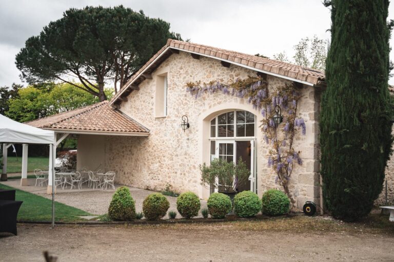 Ancien chai en pierre du Domaine Pascaud à Rions, avec sa glycine et sa grande baie cintrée