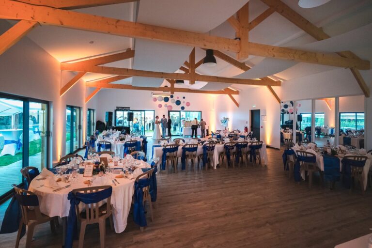 Salle de réception La Salamandre, à Andernos-les-Bains, avec sa charpente en bois et ses tables dressées