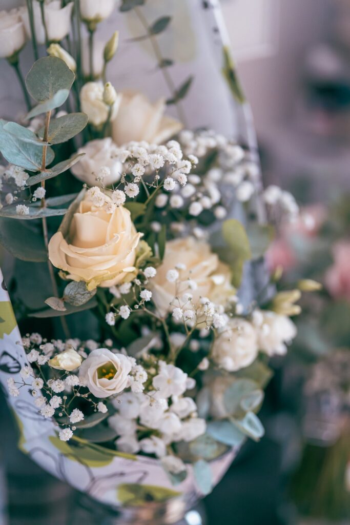 Un bouquet de roses blanches et de gypsophile, avec des feuilles d'eucalyptus.