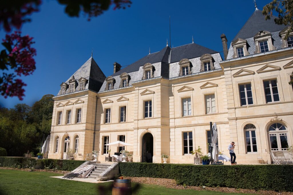La façade en pierre claire du château Fengari sous un ciel bleu, vue depuis la pelouse.