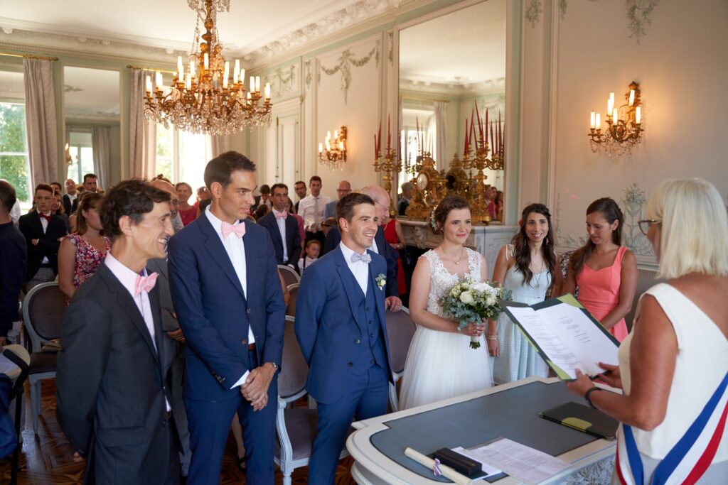 Le marié, entouré de ses témoins, attend face à l'élue en écharpe tricolore dans le salon de la mairie.