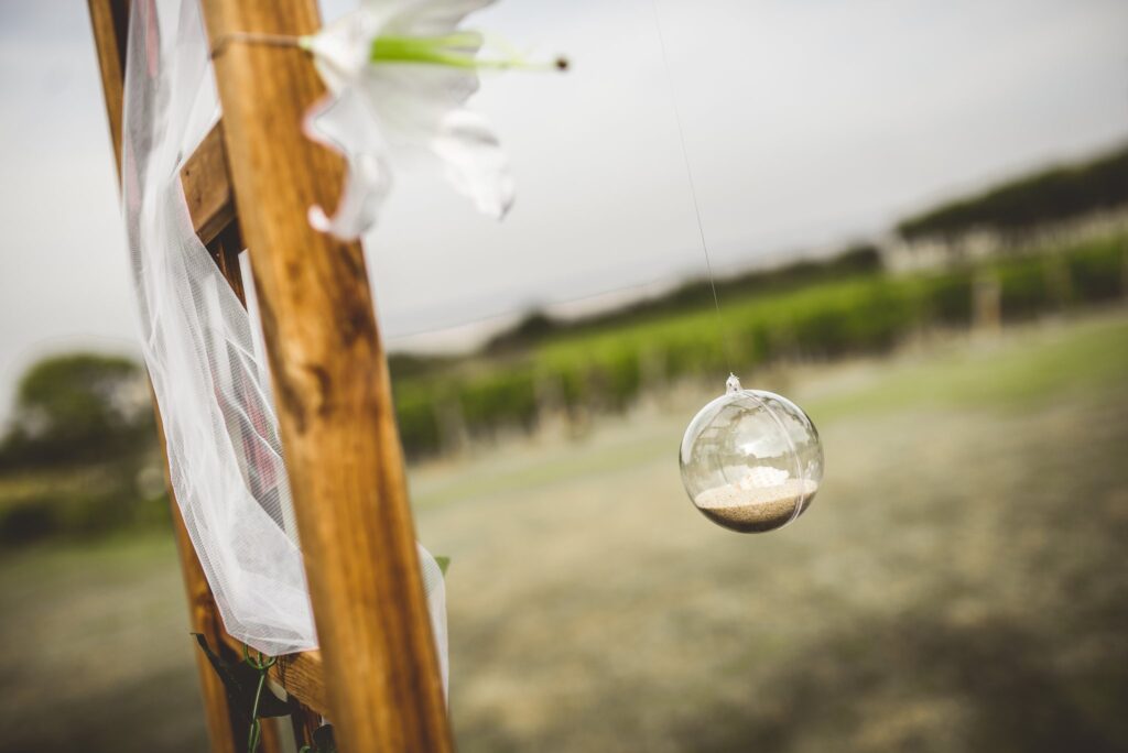 Une boule de verre contenant du sable est suspendue à un montant en bois de l'arche, devant les vignes.