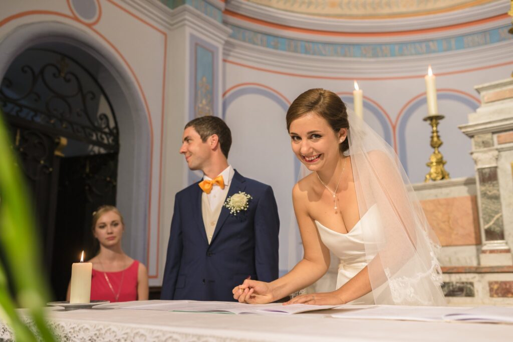 Le marié et la mariée sourient en signant le registre devant l'autel.