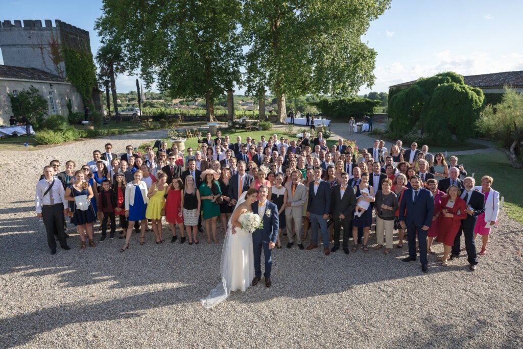 Photo de groupe vue d'en haut : les invités rassemblés sur le gravier autour des mariés.