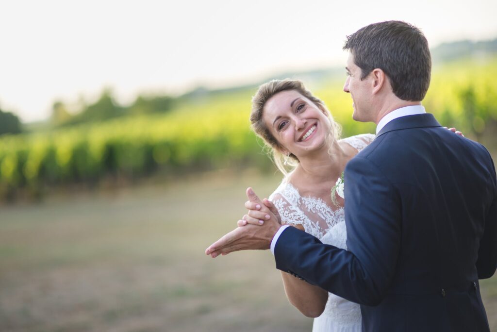 Les mariés dansent face aux vignes dans la lumière du soir.