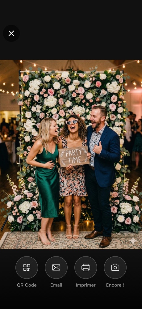 Écran de l'app Tronche! juste après la photo : trois invités posent devant un mur de fleurs, boutons QR code, email, imprimer